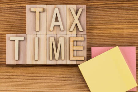 tax time -  text in vintage letters on wooden blocks with paper note. Copy space.の写真素材