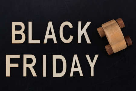 black Friday - text in wooden letters on blackBoard  with wooden car. Copy space.の写真素材