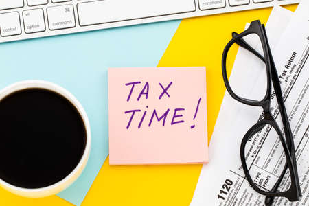 Tax Time  written on  paper note with tax form, and cup of coffee.の写真素材