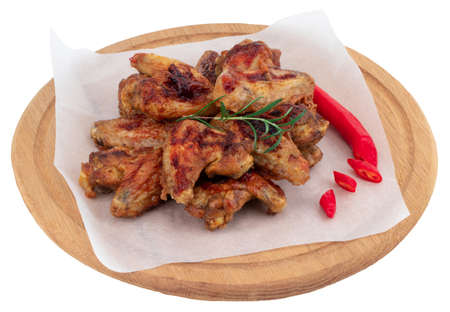 Grilled chicken wings on wooden cutting board isolated on whiteの写真素材