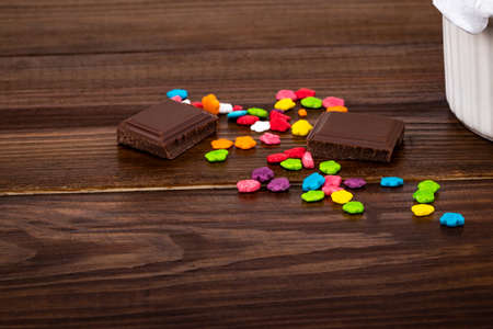 colorful sprinkles and chocolate pieces on wooden background with copy space.の写真素材