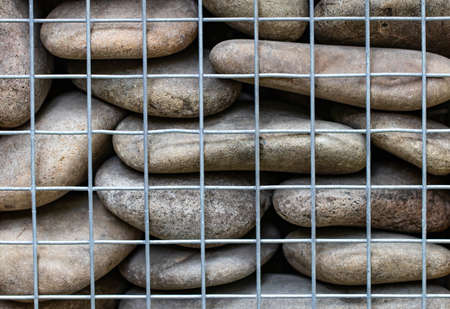 abstract background with  stones behind the net fence close-up.の写真素材