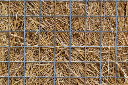 abstract background with straw behind the net fence close-up.