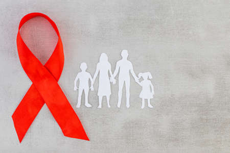 Red Ribbon and Paper silhouette of family. AIDS awareness symbol. Copy space.の写真素材