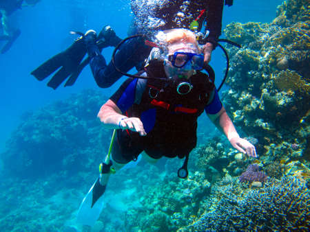 Woman scuba diver and beautiful colorful coral reef underwater.の写真素材