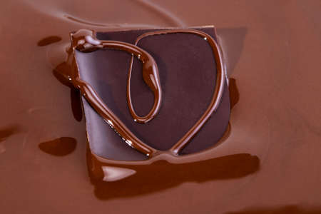 A piece of chocolate in melted chocolate.の写真素材