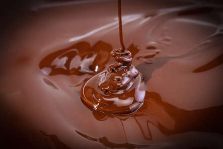 Melted chocolate swirl background. Liquid chocolate close-up.の写真素材