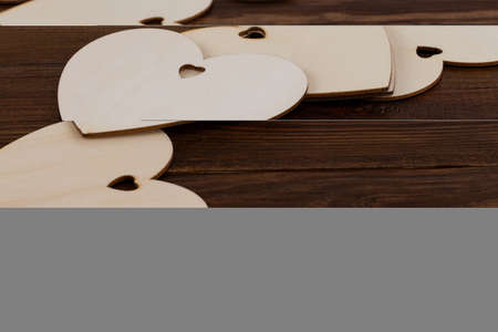 wooden hearts placed nicely on a wooden backgroud.