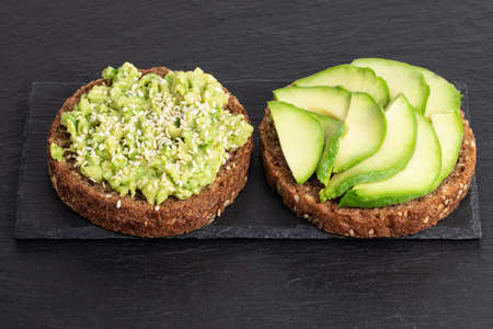 Avocado sandwich on dark rye bread on a darkの写真素材