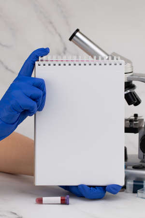Laboratory table with, test tubes with blood, with notebook with copy space.