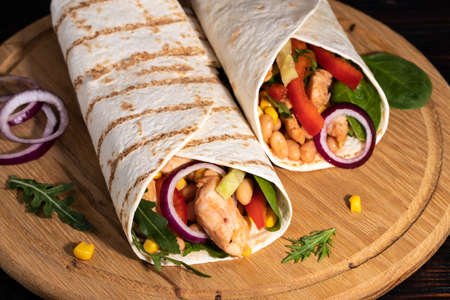 Burritos wraps with chicken and vegetables on darkの写真素材