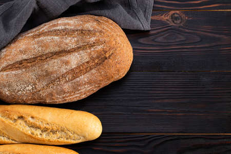 baked bread and baguette on wooden table background. Top view.の写真素材