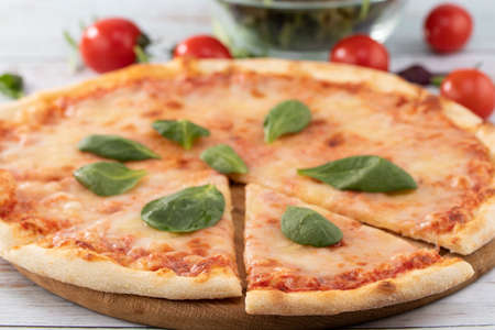 pizza with cheese sauce and spinach on wooden background.