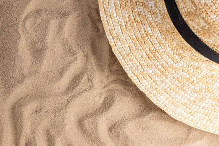 Summer vacation composition. Hat on sand background with a copy of space. Summer background.の写真素材