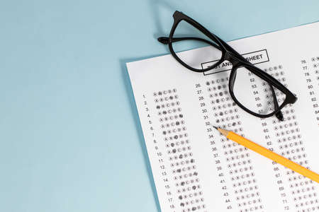 Take the exam, write the exam. Exam paper on blue background, top view copy space.の写真素材