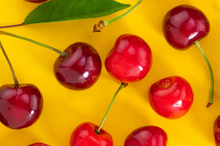 Cherries pattern on yellow background. Top view. Flat lay.の写真素材