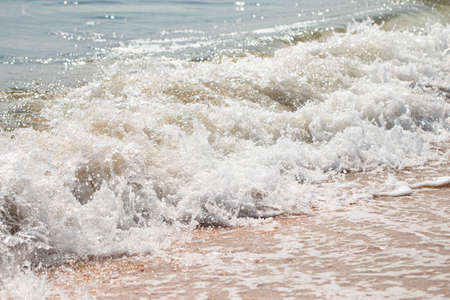 foaming sea wave on a sandy beach. Summer sea background.