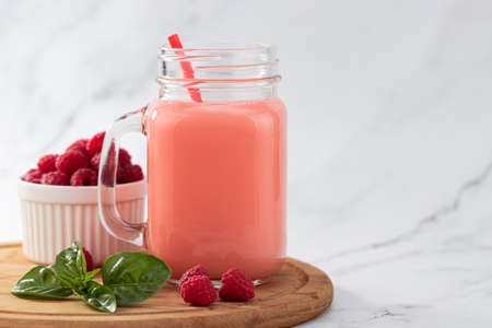 raspberries smoothie in a glass jar on the breakfast with raspberries, copy space.の写真素材