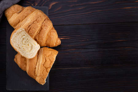 fresh croissants on dark wooden background. French breakfast. Top view flat lay with copy space.の写真素材