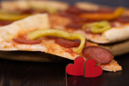 two hearts on a pizza background. Love and pizza.の写真素材