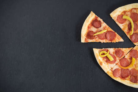 slice of pepperoni pizza on wood background. Top view of hot pepperoni pizza. With copy space. Flat lay. Banner.の写真素材