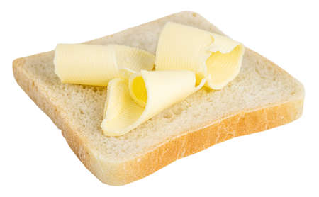 Slice of bread with butter curls on white background.の写真素材
