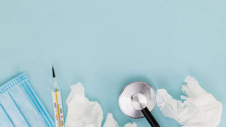 Medical mask, thermometer, stethoscope on a blue background. Virus concept.