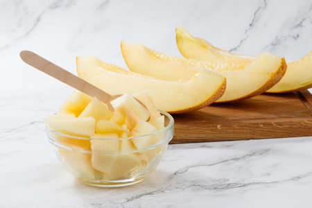 Sliced to pieces of melon. Melon Cut in a Bowl on a light background with copy space.の写真素材