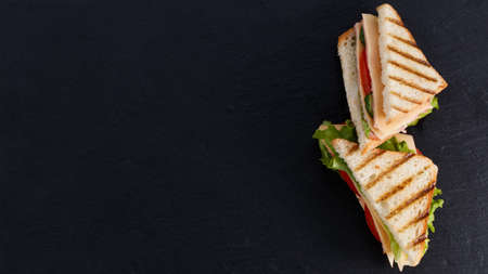 sandwich with ham and lettuce and cheese on a dark background with copy space.の写真素材