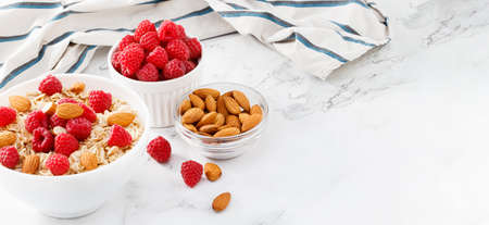 Healthy breakfast. Bowl with oatmeal with fresh raspberries and almonds. Copy space.の写真素材