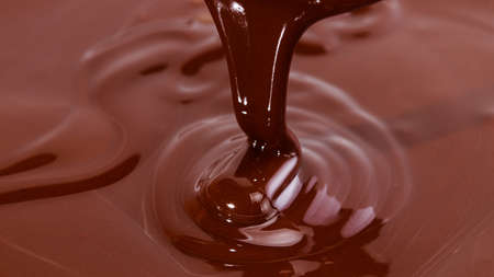Melted chocolate swirl background. Liquid chocolate close-up.の写真素材