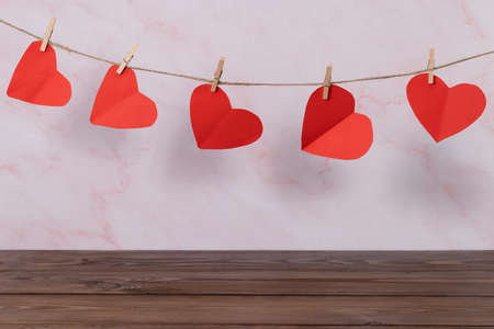 Valentines day concept. Empty wooden deck table over wall background with heart shape garland.の写真素材