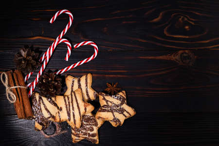 Christmas cookies, star anise, cinnamon sticks and Ñhristmas candy on wood background with copy space. Top view.の写真素材