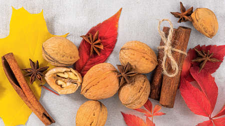 autumn background. Autumn leaves, walnuts and cinnamon sticks.