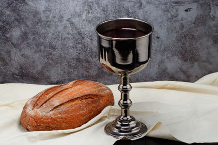 holy communion chalice with wine and bread.の写真素材