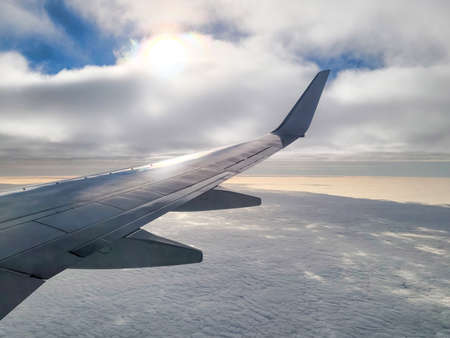 wing of an airplane flying above the blue sky clouds. Flight, travel.の写真素材