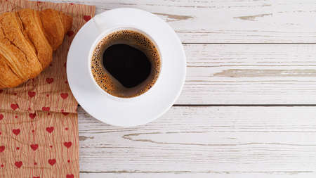 fresh croissants and coffee on light wooden background with copy space.の写真素材