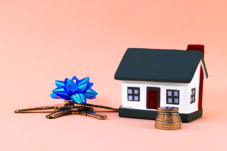 keys in a gift box and a house on a beige background.の写真素材