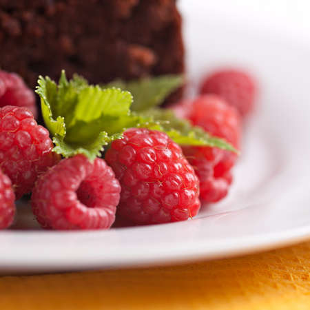 Closeup rasberries on plate with chocolate cakeの写真素材