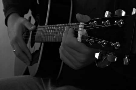 Black-white image of  man playing on the guitar