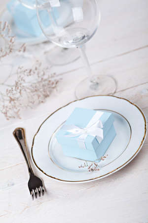 Festive table setting with blue gift on plateの写真素材