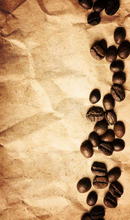 A pile of coffee beans forming a simple stripe frame on a crumpled paper backgroundの写真素材