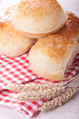 Fresh homemade bread rolls with sesam seed on tableの写真素材