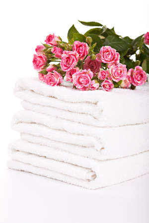 Stack of white soft towels with small pink rosesの写真素材