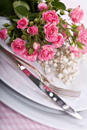 Closeup bouquet of small pink roses on plateの写真素材