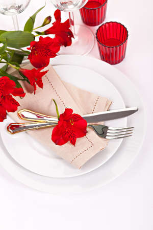 Closeup fork and knife with red alstromeria flowerの写真素材