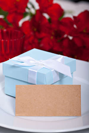 Blue gift box on plate with blank card for your textの写真素材