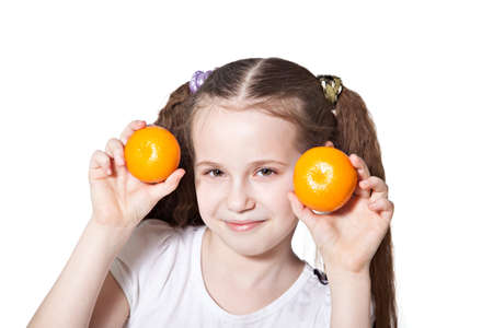 Cute smiling girl with ripe tangerines isolated over whiteの写真素材