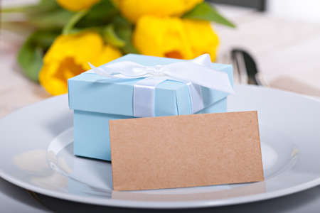 Blue gift box on plate with blank card for your textの写真素材