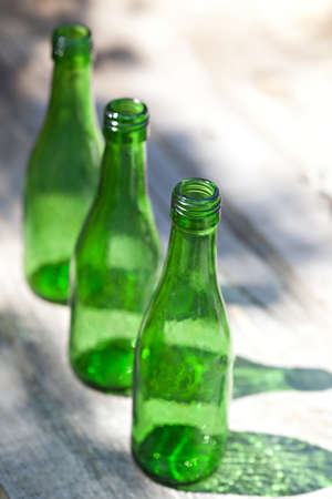 Three green empty bottles outdoorの写真素材